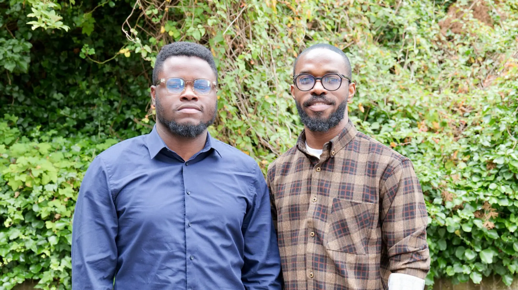 Co-founders of Stitchbloc in front of green foliage